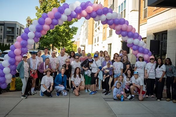 Walkers gathered under a purple, pink and white balloon arch at the Miracles To End Cancer 5K & Walk
