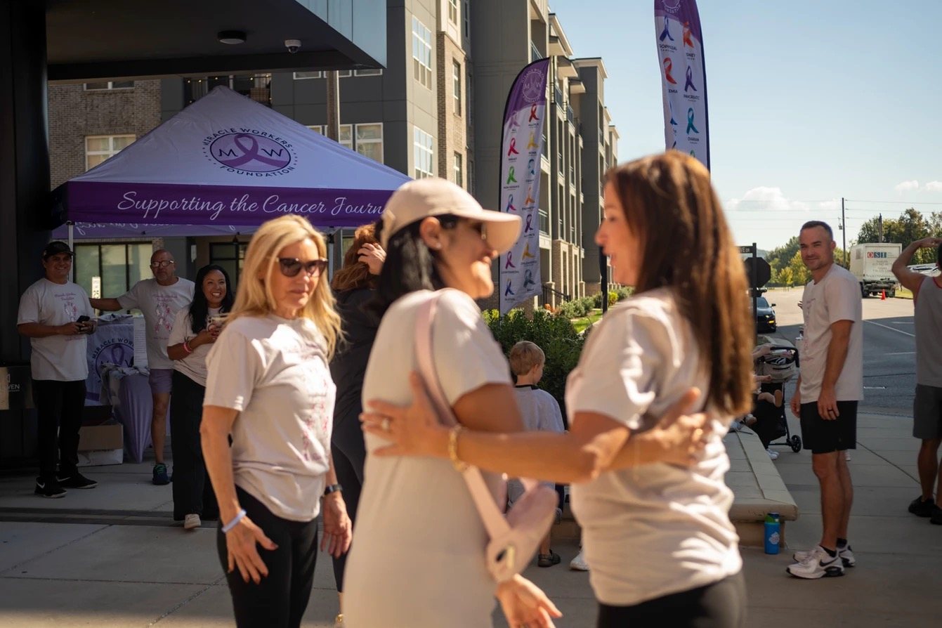 Participants greeting one another near the Miracle Workers Foundation tent